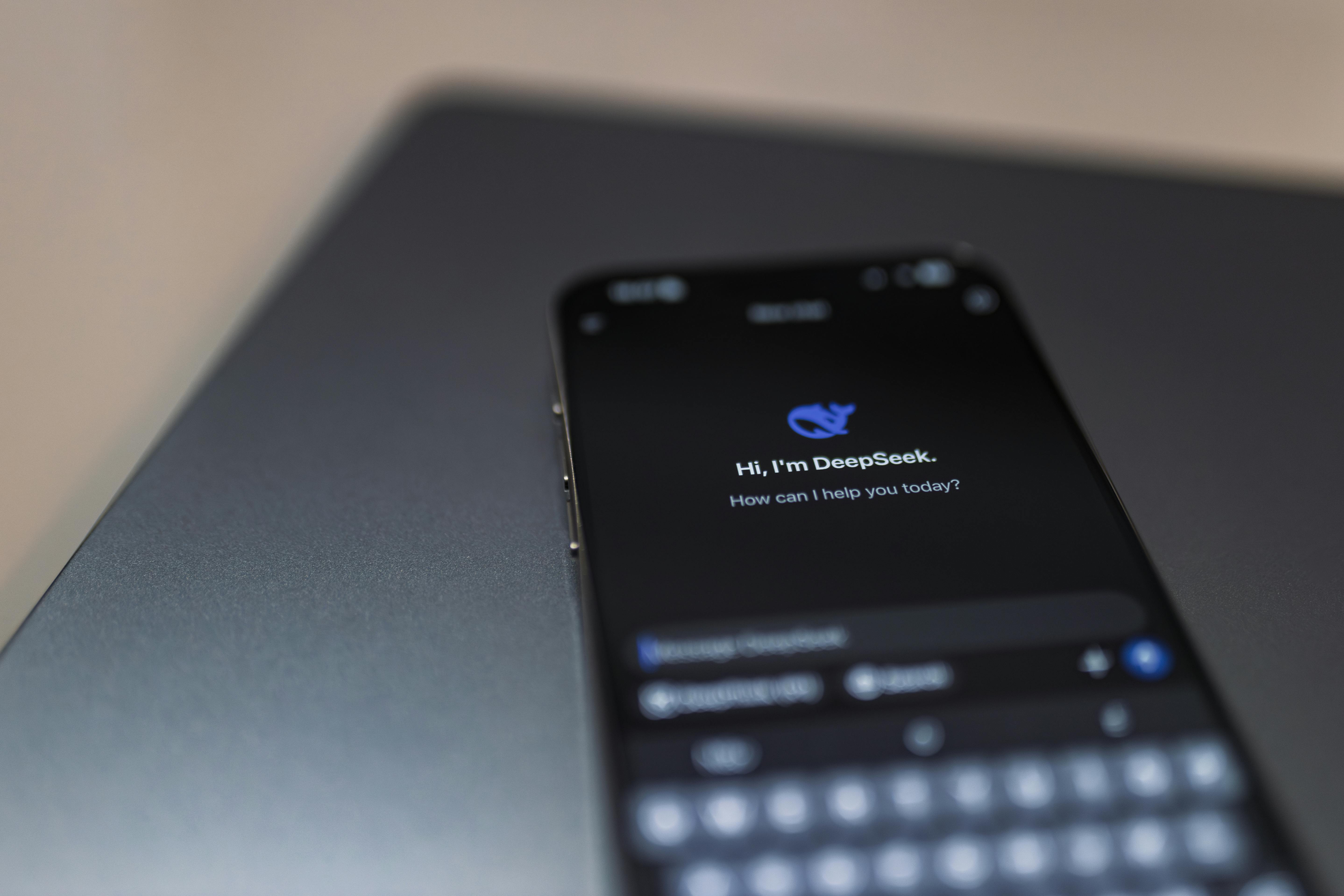 Smartphone displaying an AI chat interface beside a laptop