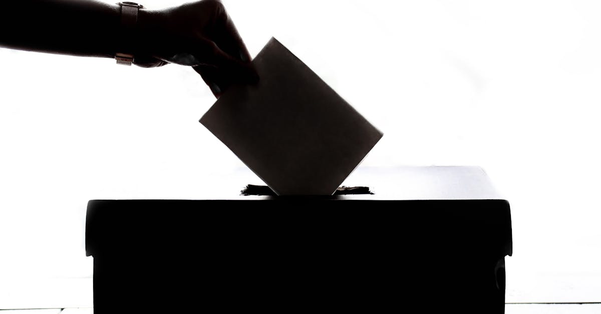 A hand placing a ballot into a ballot box, symbolizing the UK local elections