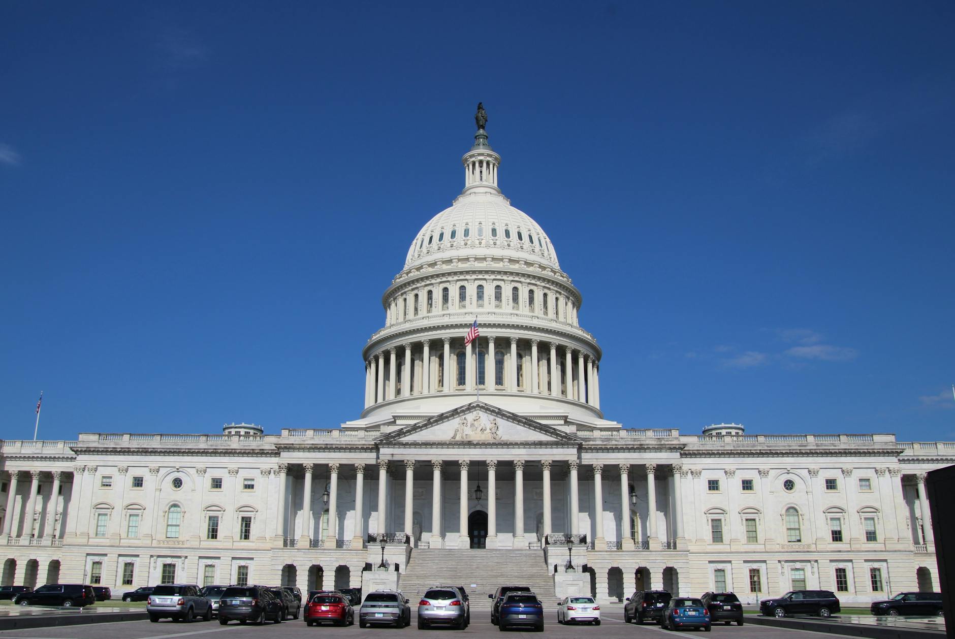 Front view of the United States Capitol building under a clear blue sky in Washington, D.C.