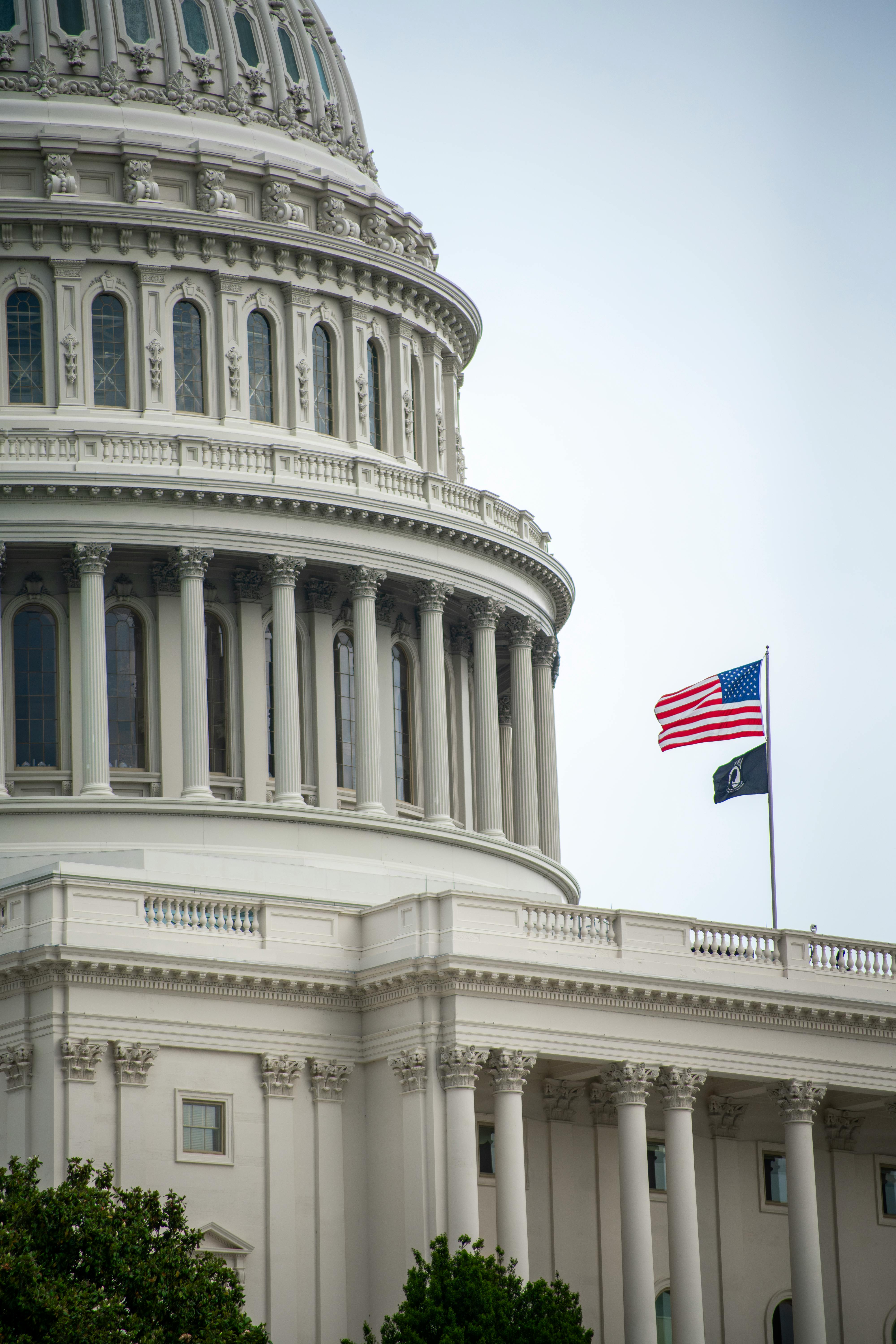 US Capitol dome and American flag in Washington, D.C., on a clear day