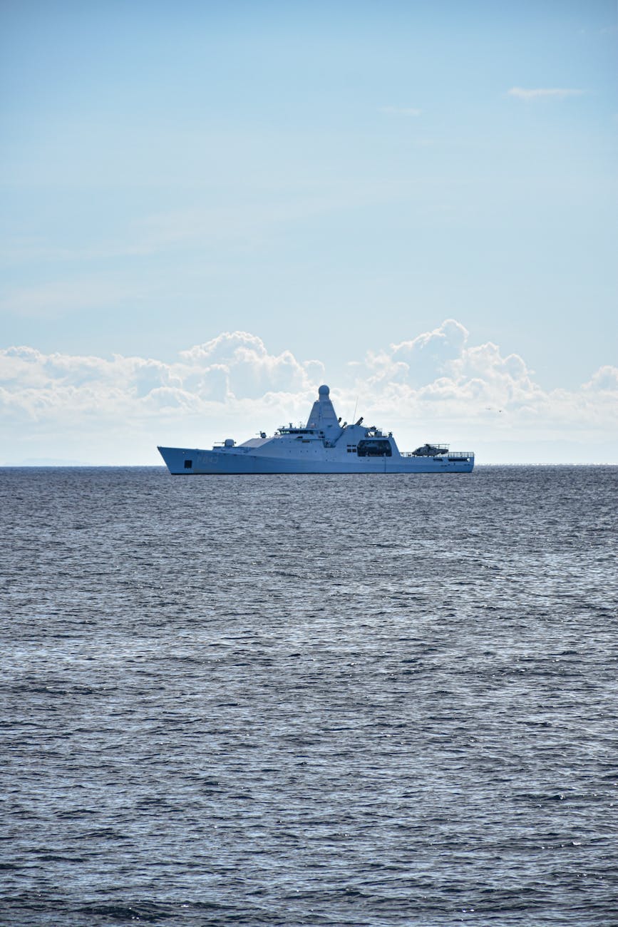 A Royal Navy-style warship sails on calm open seas, illustrative of HMS Dragon's redeployment toward the Strait of Hormuz