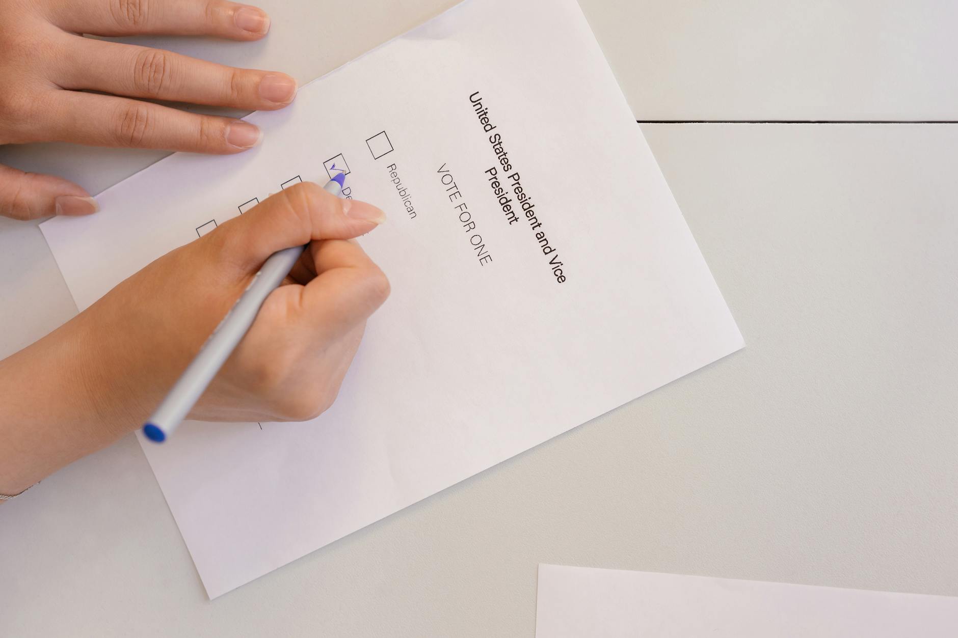 Hand placing a ballot into a voting box during an election.
