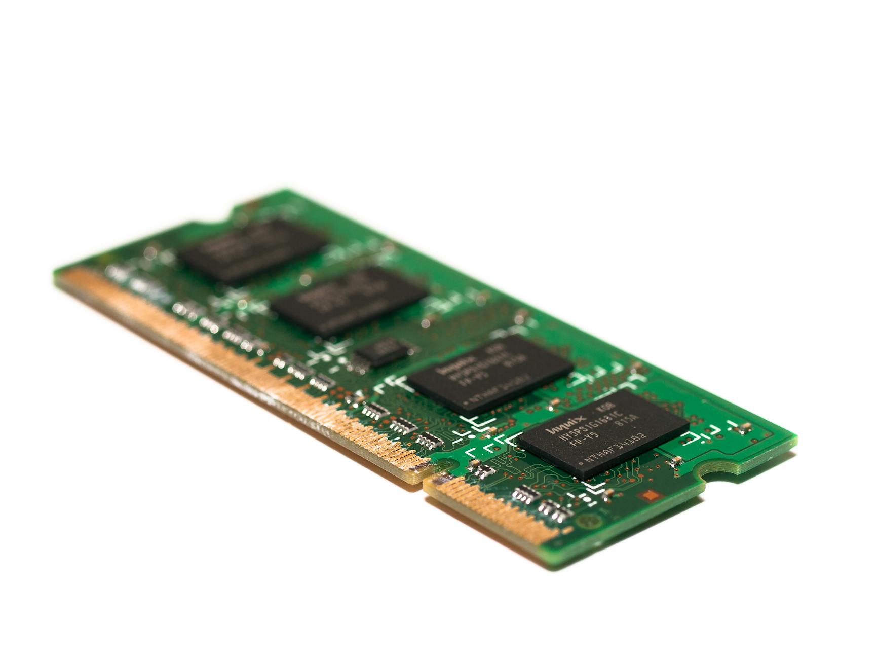 Close-up of a green DRAM memory module on a white background, illustrating high-bandwidth memory components.