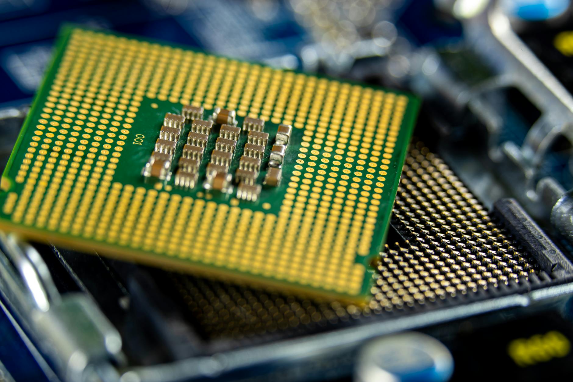 Detailed close-up of a microprocessor on a motherboard, illustrating the chip-design exposure inside QTEC