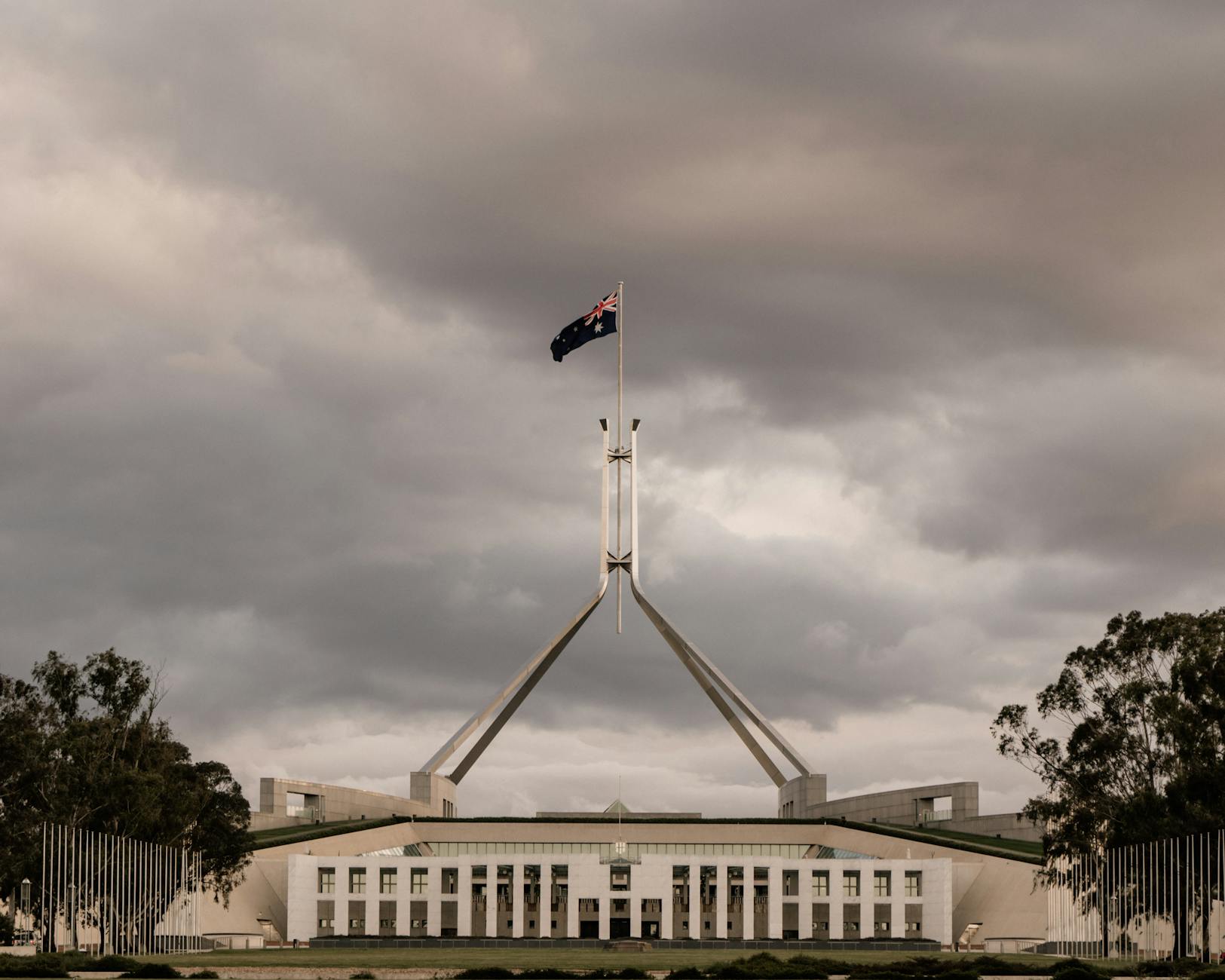 The Parliament House of Australia in Canberra under a dramatic cloudy sky