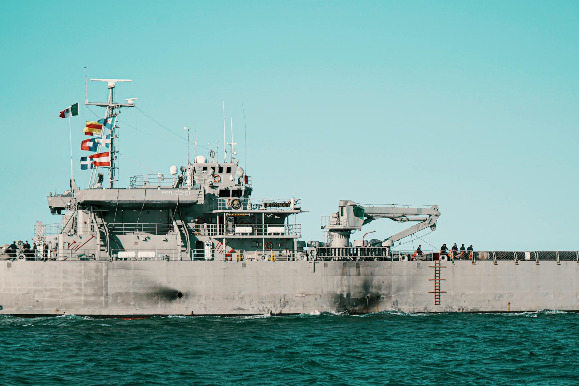 US Navy warship sailing in open waters under clear skies