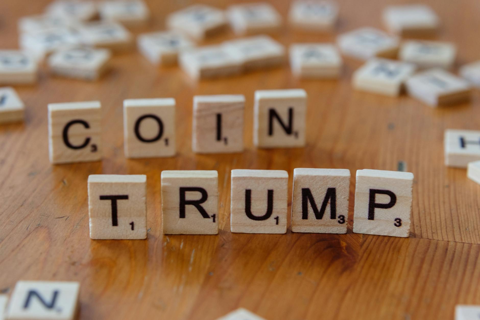 Scrabble tiles spelling 'TRUMP' on a wooden table, creating a political theme representing the Trump administration.