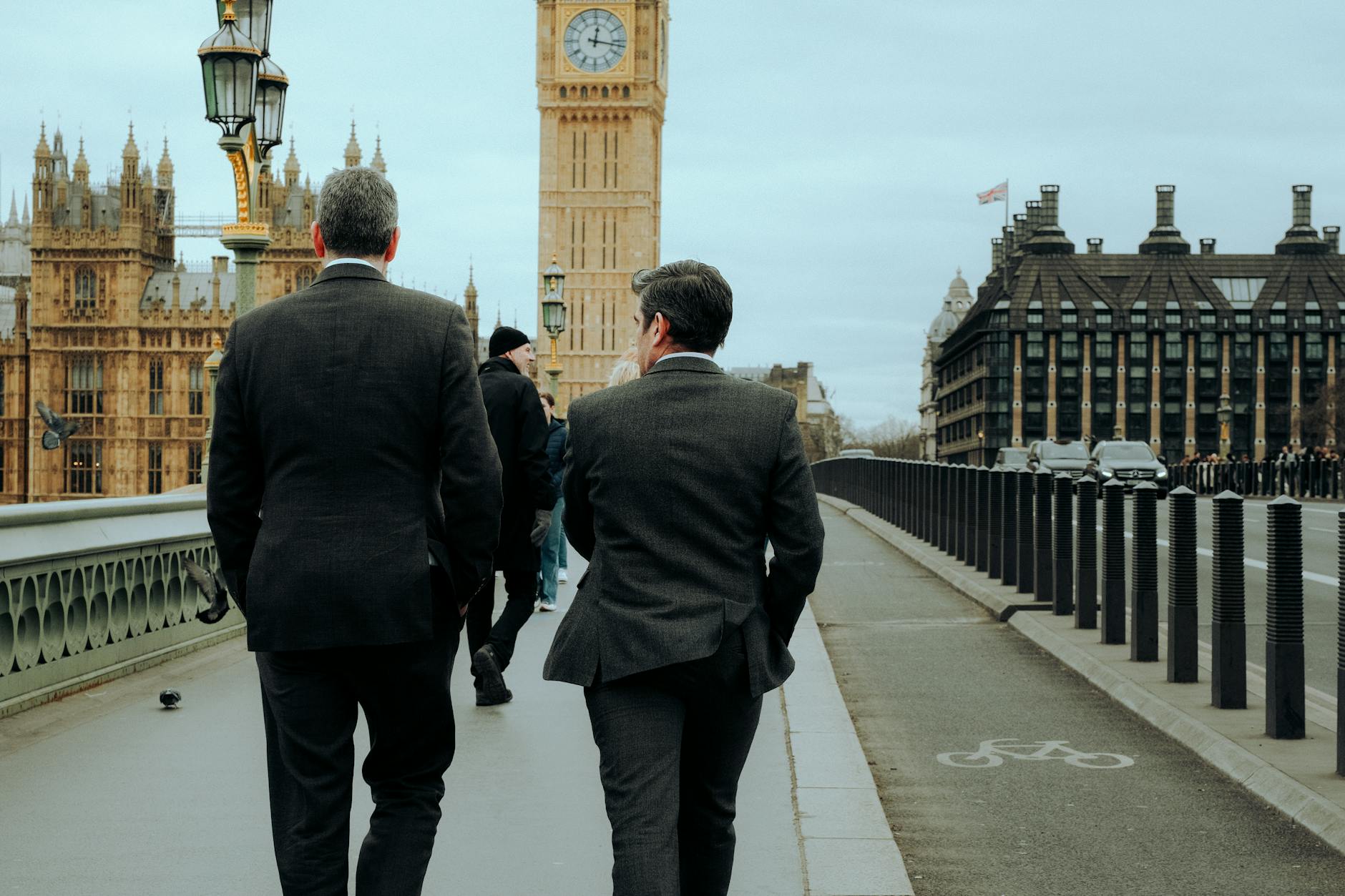 Two businessmen in suits walking on Westminster Bridge with Big Ben in the background, London