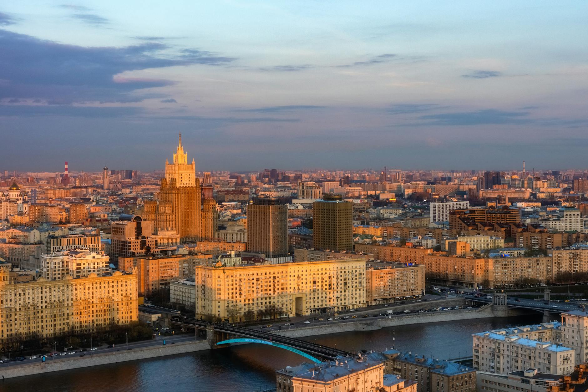 Aerial view of Moscow skyline with iconic architecture and Moskva River during sunset.