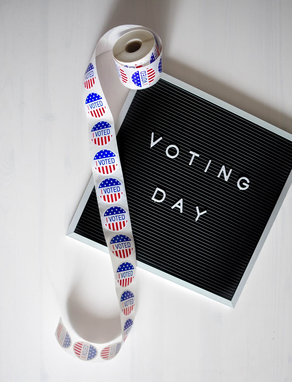 Close-up of a Voting Day sign and roll of I Voted stickers.