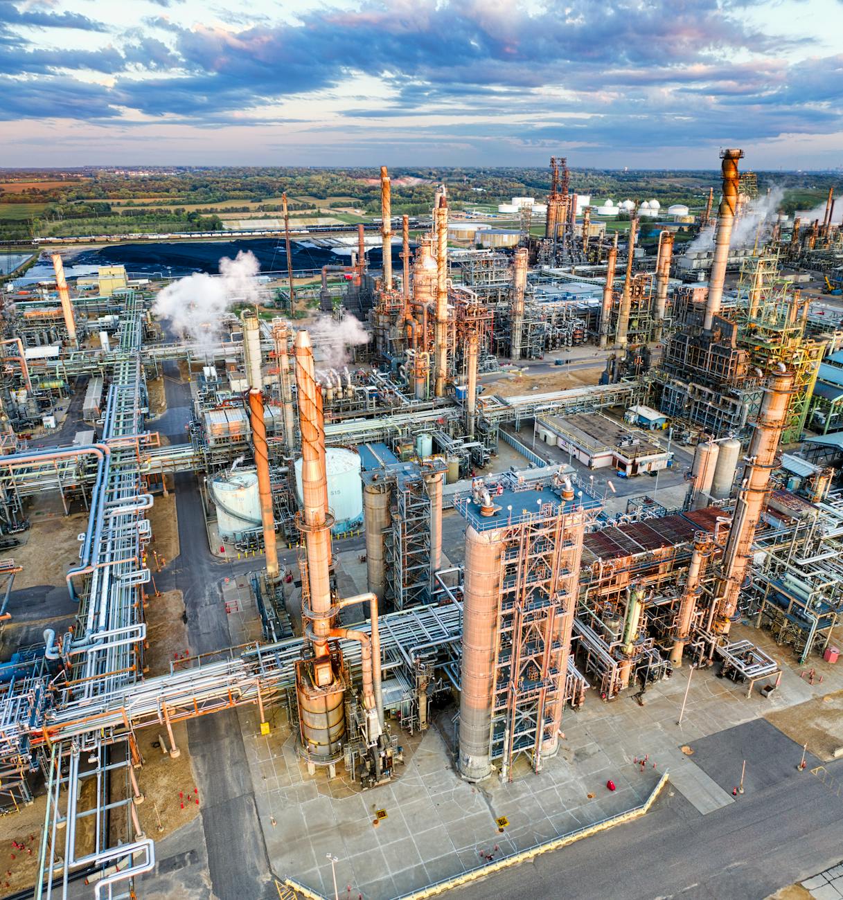 Industrial tanks and smoke at a wartime refinery