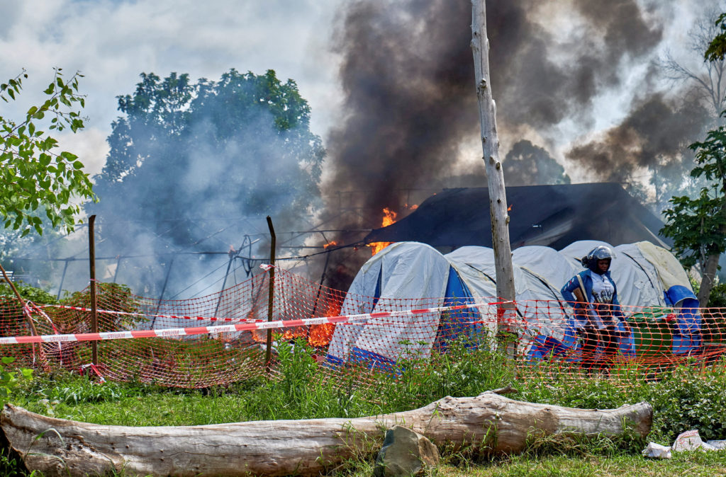 A Congolese police officer stands guard at a burning Ebola treatment center in Rwampara, outside Bunia, Ituri province, Democratic Republic of Congo, May 21. REUTERS/Gradel Muyisa Mumbere
