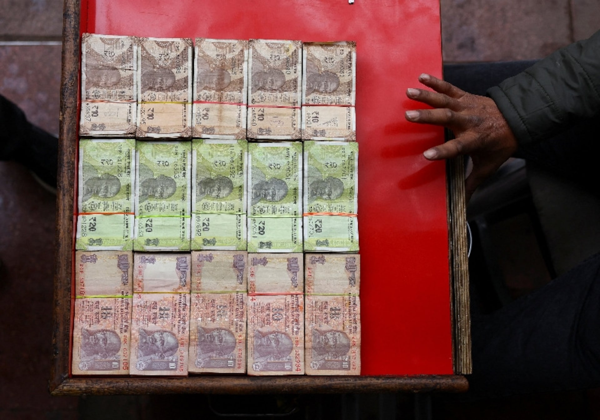 A vendor displays various denominations of Indian currency at a roadside currency exchange stall in the old quarters of Delhi, India, February 2, 2026. REUTERS/Anushree Fadnavis