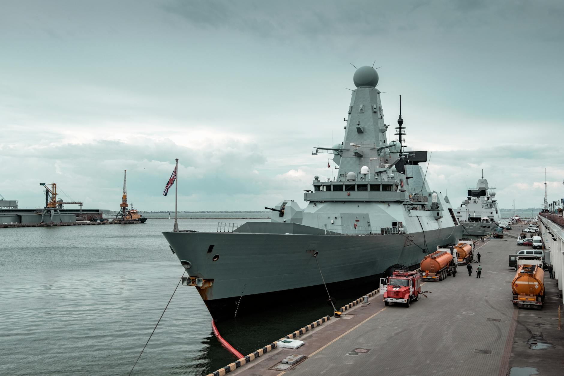 A guided-missile destroyer docked at port, illustrating the kind of escort vessel Britain is positioning for a possible Hormuz mission.