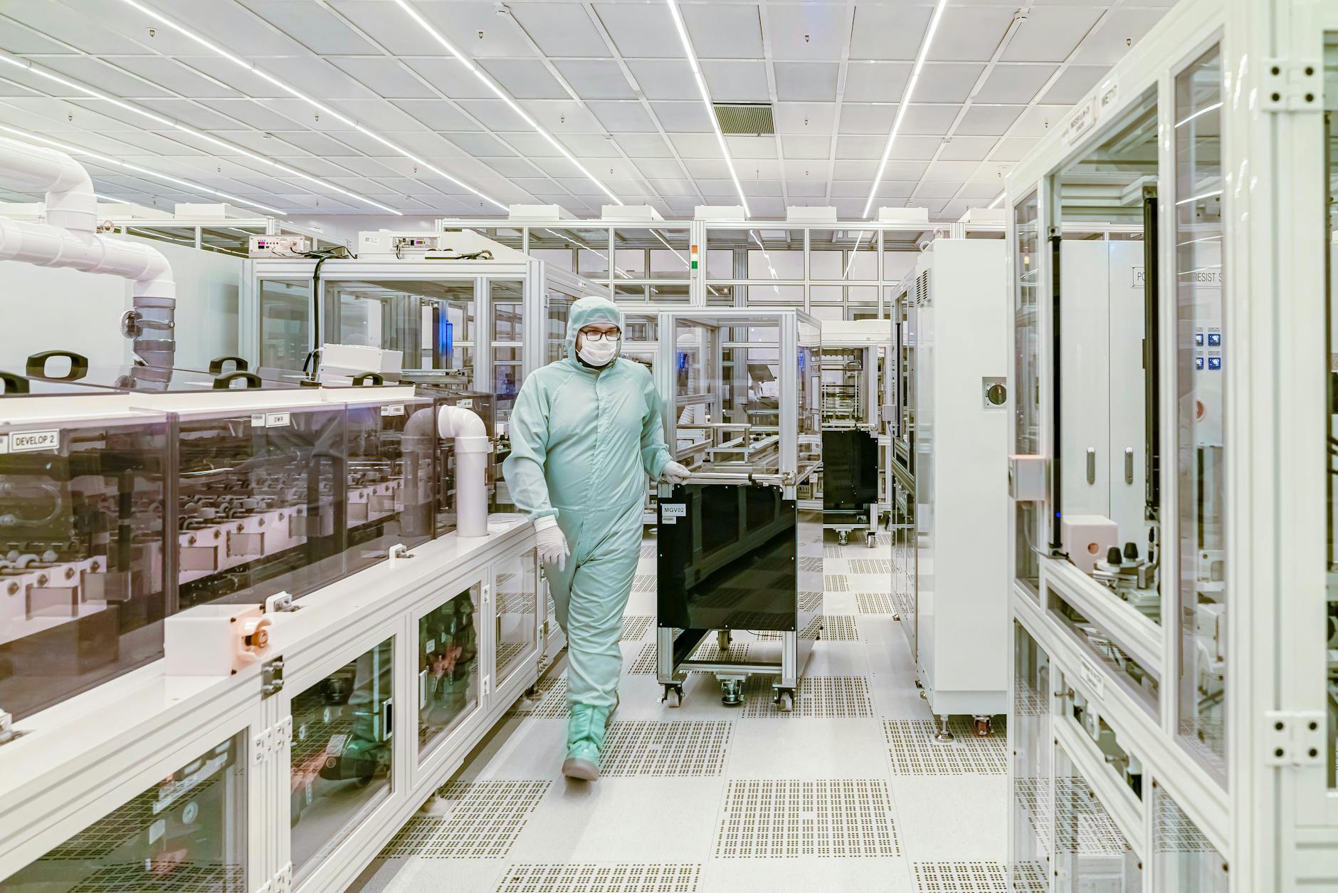 Engineer in protective gear walks through a semiconductor cleanroom