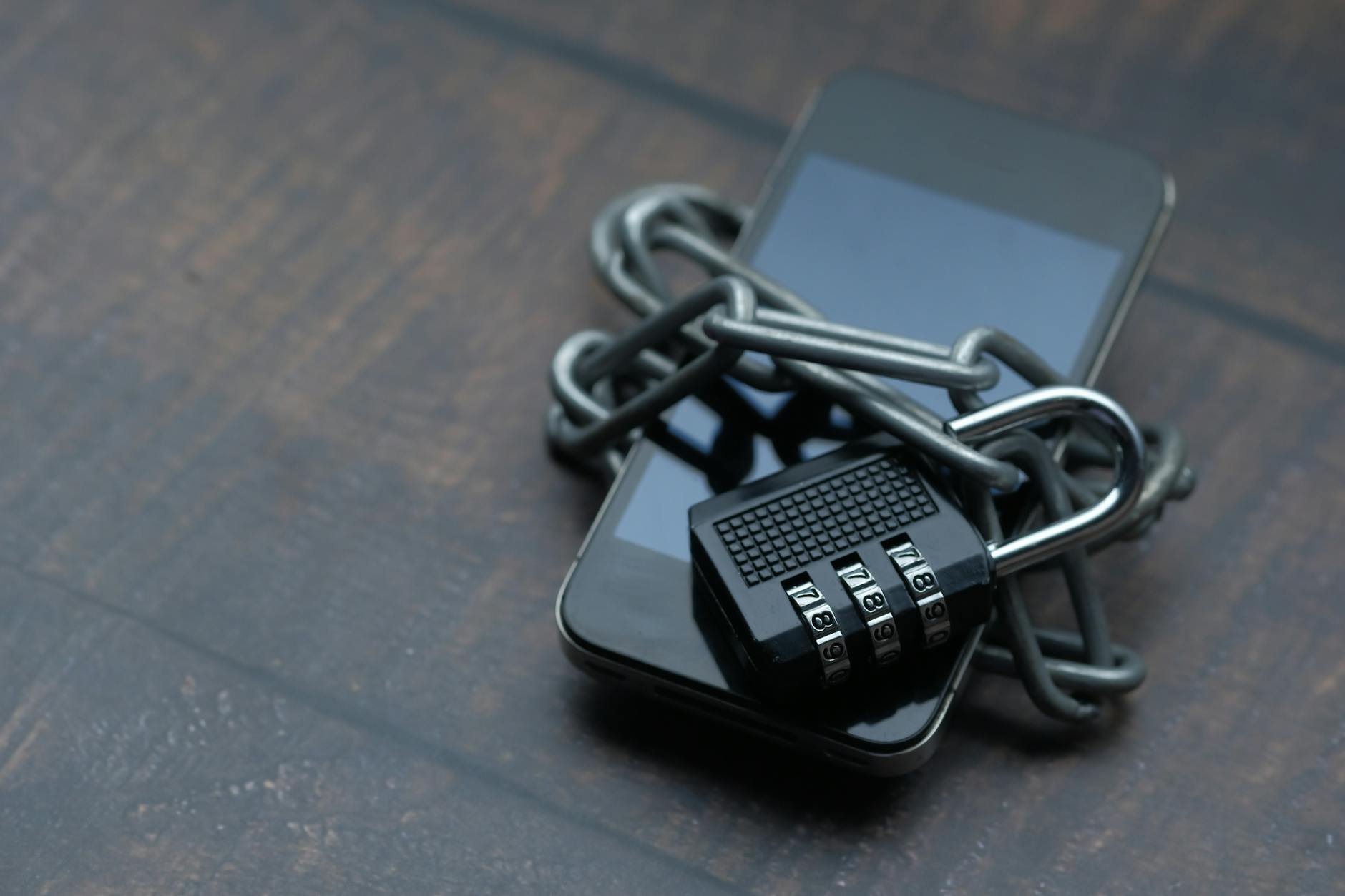 Smartphone wrapped in a chain and padlock to illustrate mobile data security concerns.