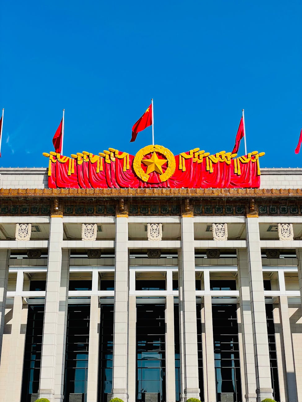 National Museum of China facade with red flags under a blue sky in Beijing