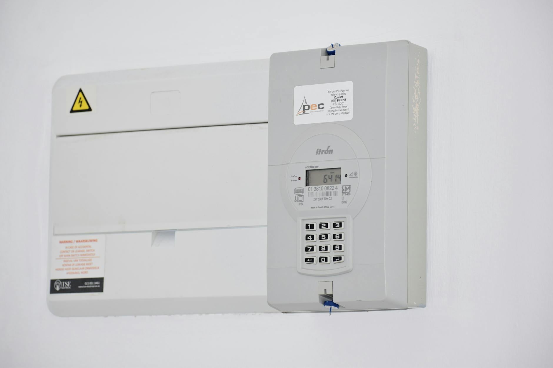 Electrical meter and fuse box on a wall, illustrating household energy billing pressure.