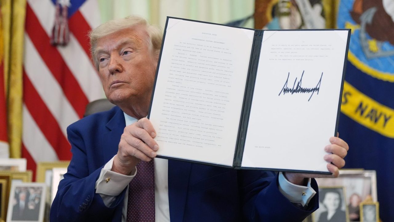 President Donald Trump holds up an executive order in the Oval Office of the White House on June 3, 2026.